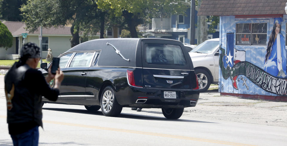 People document the hearse caring the remains of U.S. Army Specialist Vanessa Guillen, in front of a mural in honor of her as they arrived at Cesar Chavez High School Friday, Aug. 14, 2020, in Houston. Guillen, who was last seen on April 22, was laid to rest nearly four months after she is said to have been killed by a fellow soldier at Fort Hood, a U.S. Army base in Texas. (Steve Gonzales/Houston Chronicle via AP)