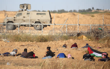 Palestinians take cover during a protest at the Israel-Gaza border fence, in the southern Gaza Strip May 3, 2019. REUTERS/Ibraheem Abu Mustafa