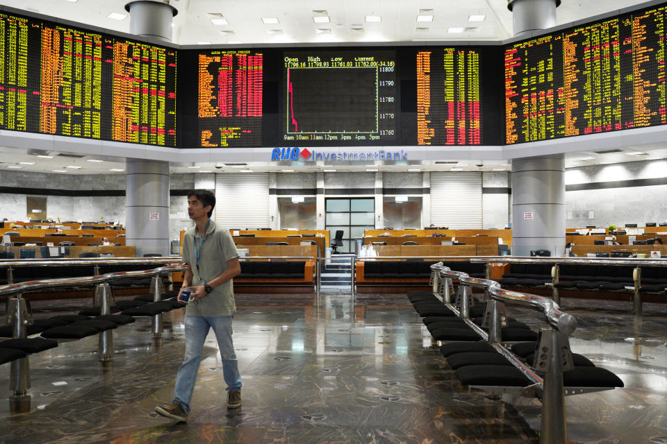 An Investor walks in front of private stock trading boards at a private stock market gallery in Kuala Lumpur, Malaysia, Friday, Nov. 23, 2018. Asian markets are mostly lower as traders dwelled on risks from a drawn-out dispute between the U.S. and China and other events closer to home. (AP Photo/Yam G-Jun)