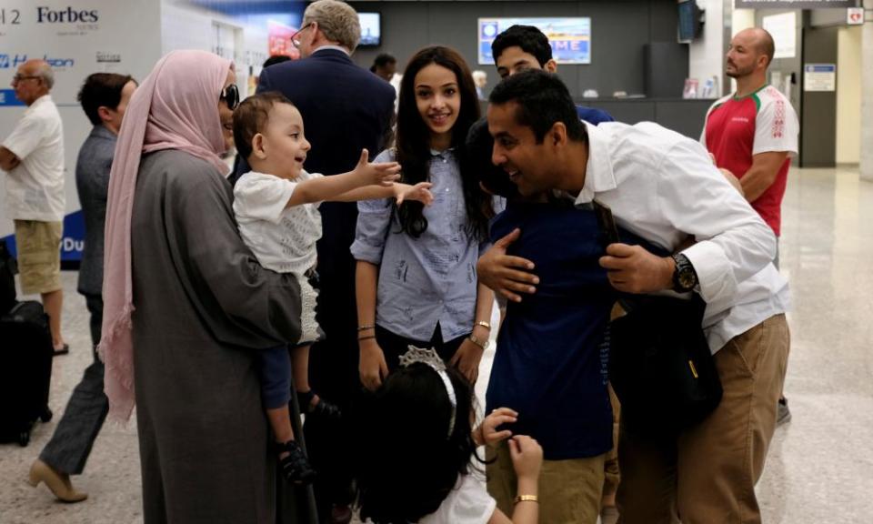 A family embraces each other as members arrive at Washington Dulles international airport after the supreme court granted parts Trump’s travel ban into effect on Monday.