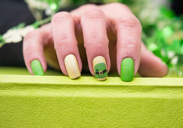 a st patricks day inspired manicure with a leprechaun hat painted on one nail
