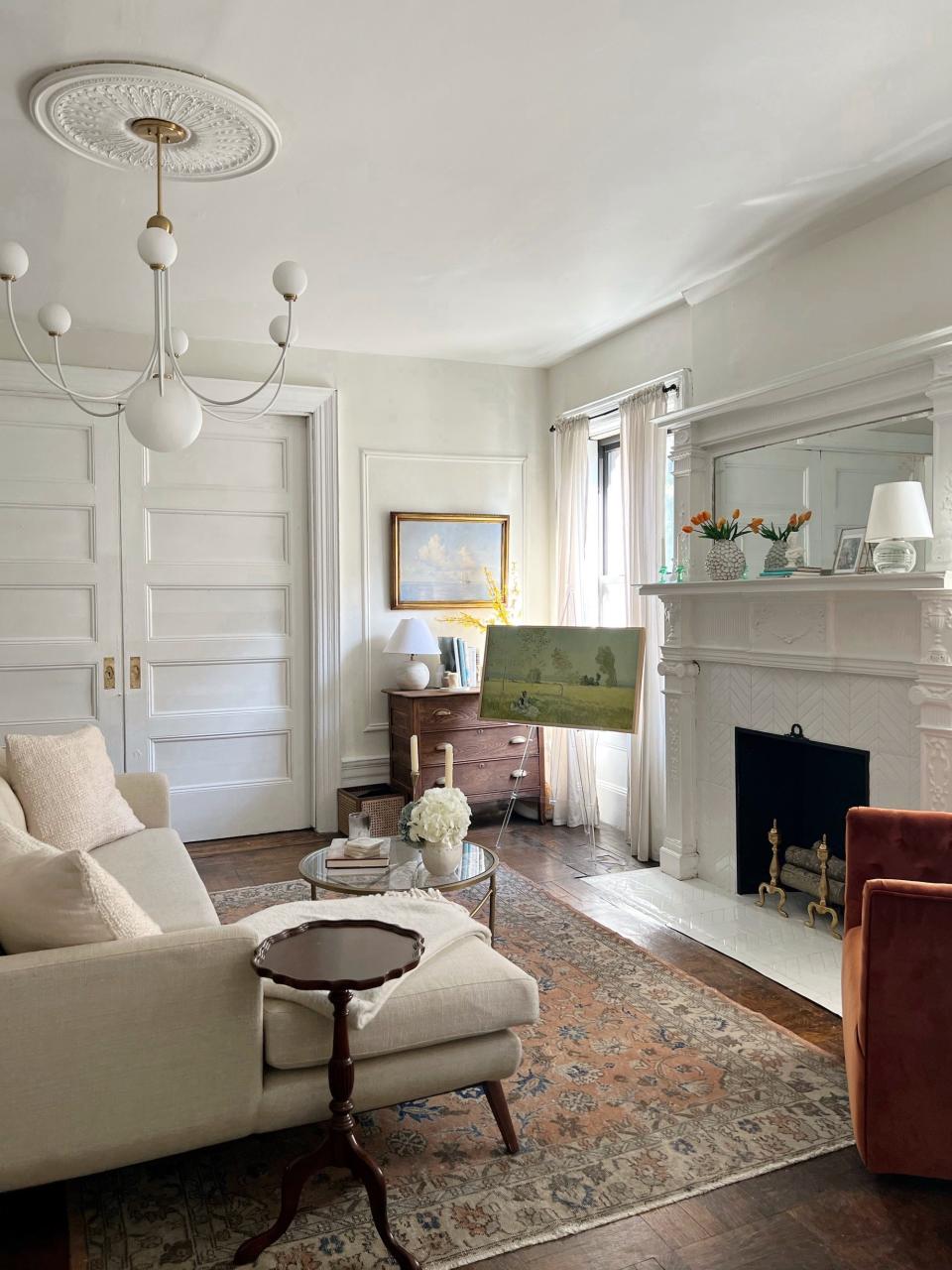 A living room with a white fireplace and white pocket doors.