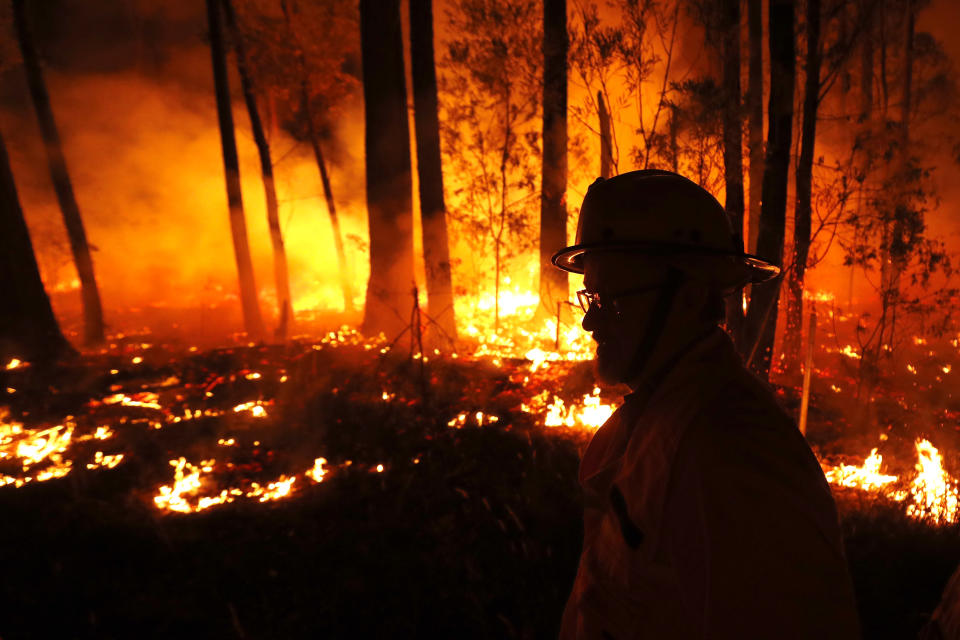 Crews monitor fires and begin back burns between the towns of Orbost and Lakes Entrance in East Gippsland on Jan. 02 in Australia. The HMAS Choules docked outside of Mallacoota to evacuate thousands of people stranded in the remote coastal town following fires across East Gippsland, which have killed one person and destroyed dozens of properties. (Photo by Darrian Traynor/Getty Images)