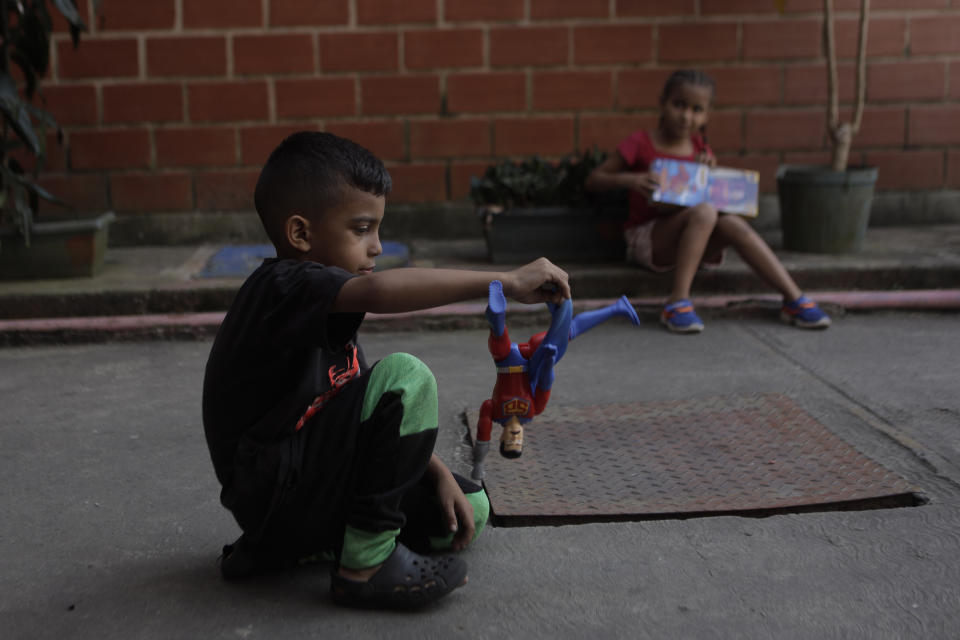 Children play with "Super Bigote" dolls in the Carayaca neighborhood of La Guaira , Venezuela, Tuesday, Dec. 27, 2022. The delivery of toys of "Super Bigote" or Super Mustache and "Cilita" dolls based on the image of Venezuelan President Nicolas Maduro and his wife Cilia Flores, were handed to thousands of children this Christmas, causing controversy among some Venezuelans. (AP Photo/Jesus Vargas)