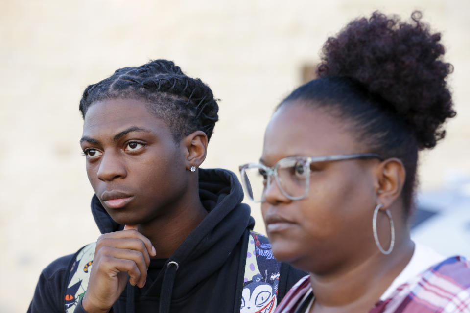 FILE - Darryl George, left, a 17-year-old junior, and his mother Darresha George, right, talks with reporters before walking across the street to go into Barbers Hill High School after Darryl served a 5-day in-school suspension for not cutting his hair Monday, Sept. 18, 2023, in Mont Belvieu. George will spend the remainder of the year in in-school suspension, extending a punishment that was first imposed in August over his hairstyle that district officials maintain violates their dress code policy. A referral given to George Tuesday, Dec. 5, said his hair is “out of compliance” with the dress code at Barbers Hill High School in Mont Belvieu, Texas. (AP Photo/Michael Wyke, File)