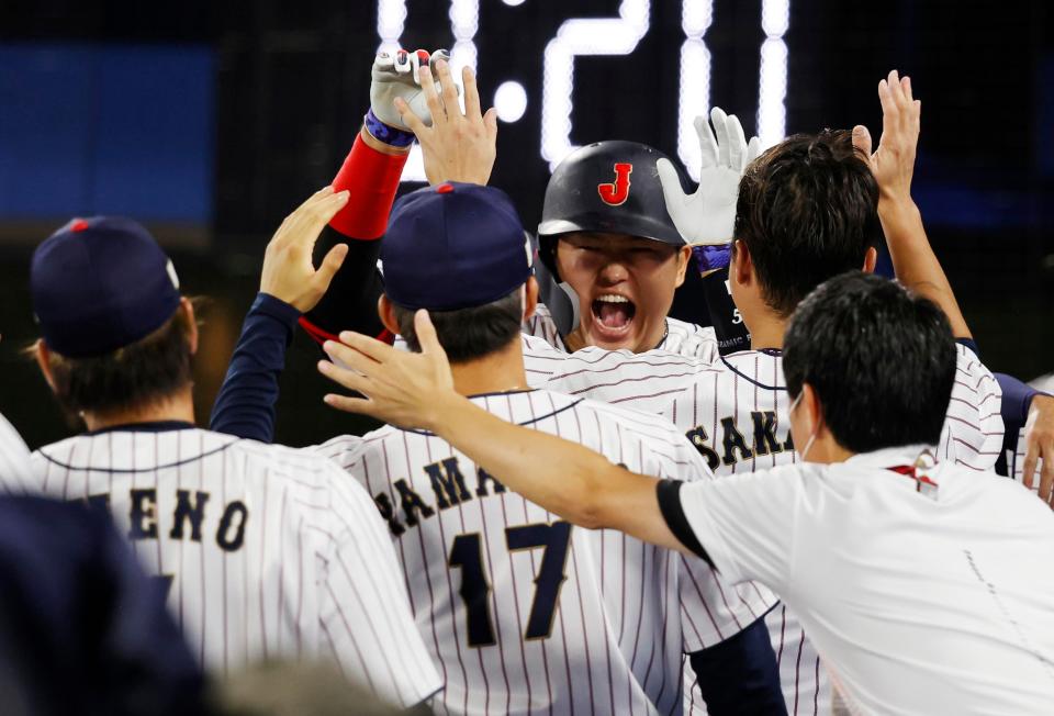 Team Japan infielder Munetaka Murakami (55) celebrates with teammates after hitting a solo home run against the USA.