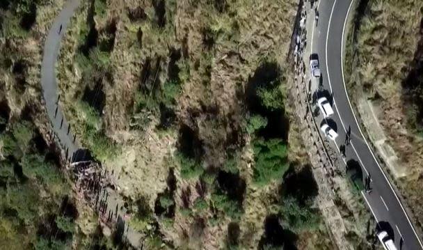 An aerial image from video provided by police in India's Jammu and Kashmir state shows, at lower left, a bus that crashed off a road (at right) and then 600 feet down a gorge, leaving at least 36 people dead on Nov. 15, 2023. / Credit: JAMMU AND KASHMIR POLICE HANDOUT