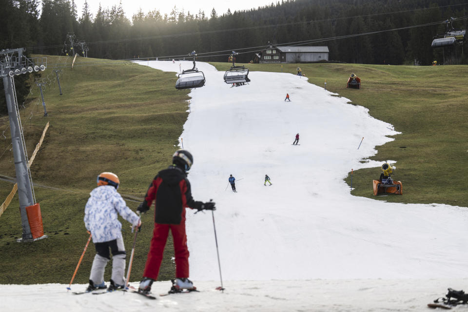 FILE - People skiing on a slope of artificial snow in Wildhaus, Switzerland, Wednesday, Jan. 4, 2023. The Swiss alps are confronted with a lack of snow and warm temperatures. (Gian Ehrenzeller/Keystone via AP, File)