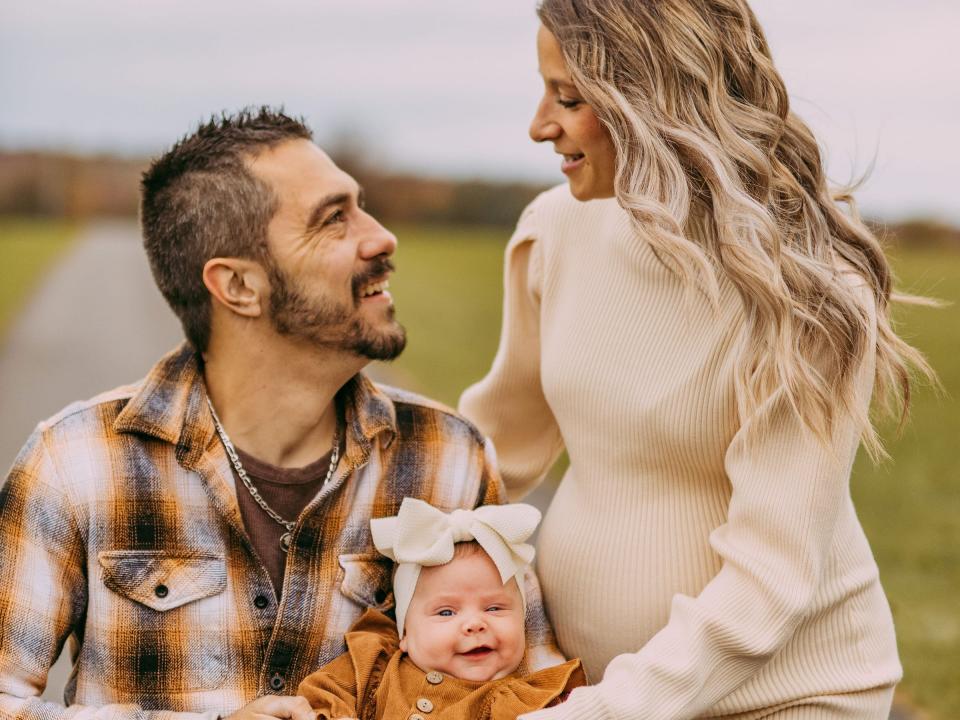 Zac and Brittney Wolfe, who are pregnant with triplets, with their recently adopted baby girl, Charlie. 