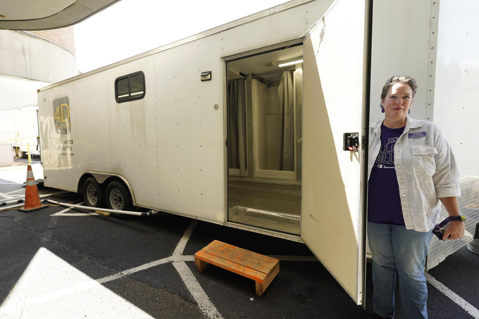 Annie S. Mitchell, vice president for Marketing and Communications at Millsaps College in midtown Jackson, Miss., shows off the interior of one of the sets of portable showers the school rented for the 200 students that remained on campus during the city's latest water crisis, Thursday, Sept. 1, 2022. (AP Photo/Rogelio V. Solis)