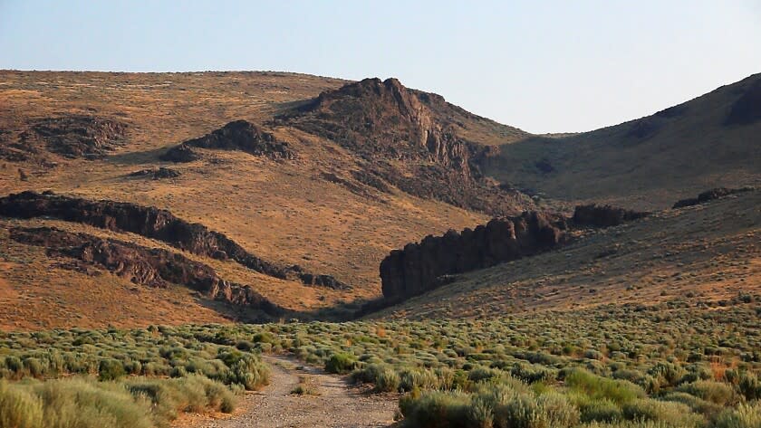 FILE — In this July 14, 2021 file photo the Montana Mountains loom over Thacker Pass in northern Nevada. A pair of lithium mines and a geothermal power plant in the works in Nevada are among the most ambitious projects at the forefront of the Biden administration's "green" energy agenda. The three ventures at various stages of development in the biggest U.S. gold producing state also are shining a spotlight on the hurdles ahead. (Jason Bean/The Reno Gazette-Journal via AP)