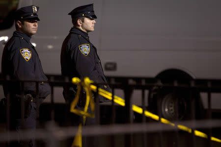 Police are pictured at the scene of a shooting where two New York Police officers were shot dead in the Brooklyn borough of New York, December 20, 2014. REUTERS/Carlo Allegri