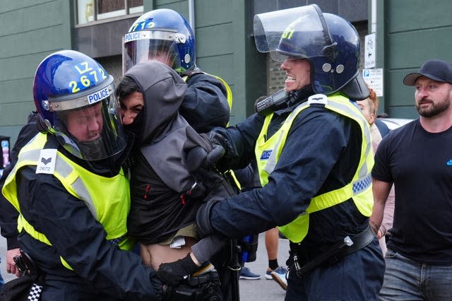 A man is detained by three police officers