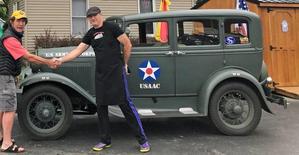Jay Burbank, at left, and Tully Garrett of Wilmington, Illinois, pose in 2019 after Garrett signed his father’s name on Burbank’s 1931 Model A, in honor of the man’s military service, wartime injuries and experiences. It was the first of hundreds of veterans’ autographs Burbank has collected on the antique auto since then.