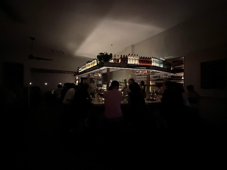 <p>A photo from the iPhone 14 Pro's wide camera of a bright bar in a dark restaurant.</p>
