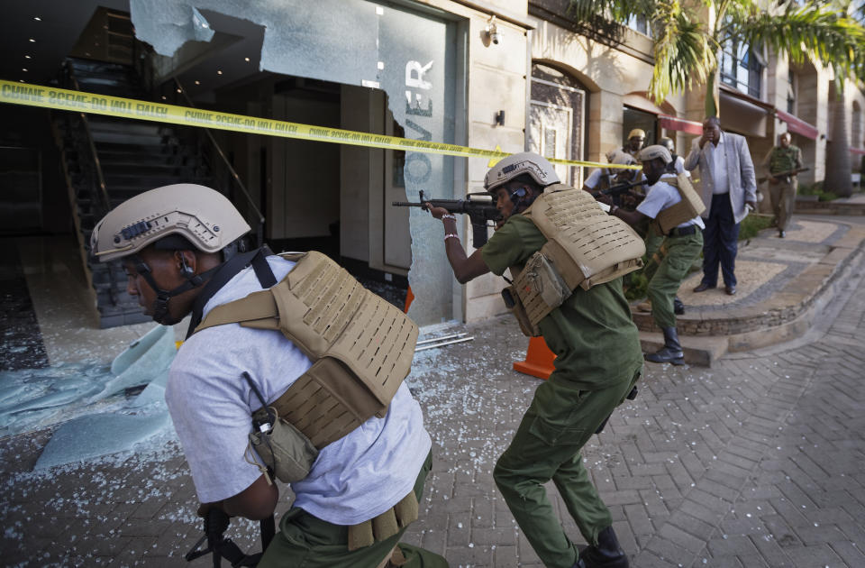 Security forces point their weapons through a shattered door behind which an unexploded grenade lies, at a hotel complex in Nairobi, Kenya, Tuesday, Jan. 15, 2019. Terrorists attacked an upscale hotel complex in Kenya's capital Tuesday, sending people fleeing in panic as explosions and heavy gunfire reverberated through the neighborhood. (AP Photo/Ben Curtis)