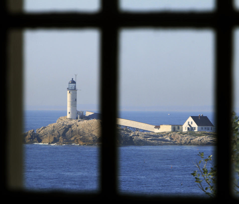 In this photo taken Friday, Sept. 14, 2012, the lighthouse on White Island can be seen through the church window at the historic Star Island Family Retreat and Conference Center at the Isle of Shoals in Rye, N.H. The hotel 10 miles off the coast of New Hampshire wants to establish itself as an environmental leader. The island is essentially a self-contained system, and it is an ideal spot to showcase energy innovations and could be become a model for other communities. (AP Photo/Jim Cole)