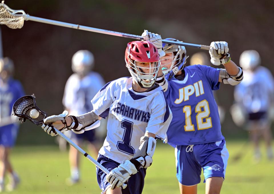 Ryan Woeller of Cape Cod Academy drives past Mark Rogers of St. John Paul II on Monday, May 1, 2023.