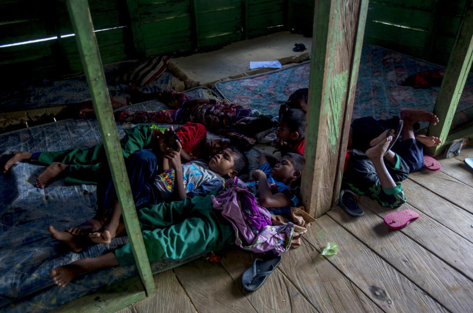 Students of a boarding school rest in their dormitory in North Kalimantan, Indonesia, on Tuesday, April 9, 2019. Some palm oil workers who work illegally in Malaysia send their children to the school in this transit town because they have no access to education in Malaysia due to their parents' employment status. (AP Photo/Binsar Bakkara)
