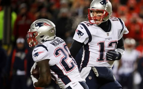 New England Patriots quarterback Tom Brady hands off the ball to running back Sony Michel (26) during the first half of the AFC Championship NFL football game, Sunday, Jan. 20, 2019, in Kansas City - Credit: AP