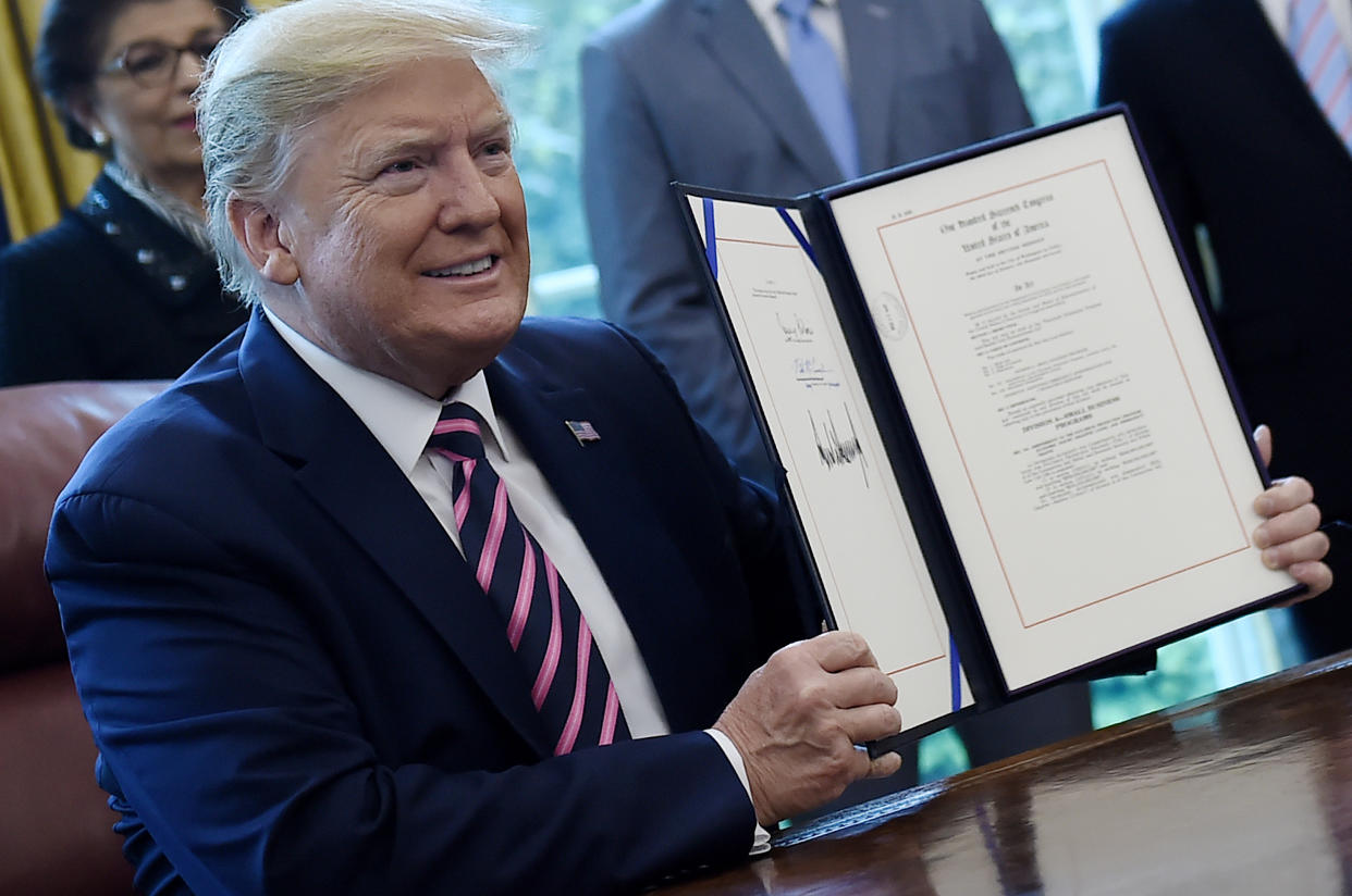 US President Donald Trump holds the signed Paycheck Protection Program and Health Care Enhancement Act in the Oval Office of the White House in Washington, DC, on April 24, 2020. - The $483 billion stimulus act will back small businesses on the brink of bankruptcy, and allocate more money for health-care providers and virus testing. (Photo by Olivier DOULIERY / AFP) (Photo by OLIVIER DOULIERY/AFP via Getty Images)