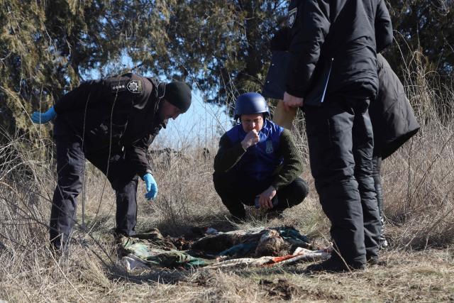 EDITORS NOTE: Graphic content / A war crimes prosecutor (C) and Ukrainian police forensic team examine the exhumed remains of Olena Trofimova, 51-year-old, killed on June 25, 2022 during the Russian invasion, at the cemetery of Davydiv Brid, near Kherson, southern Ukraine, on February 16, 2023.