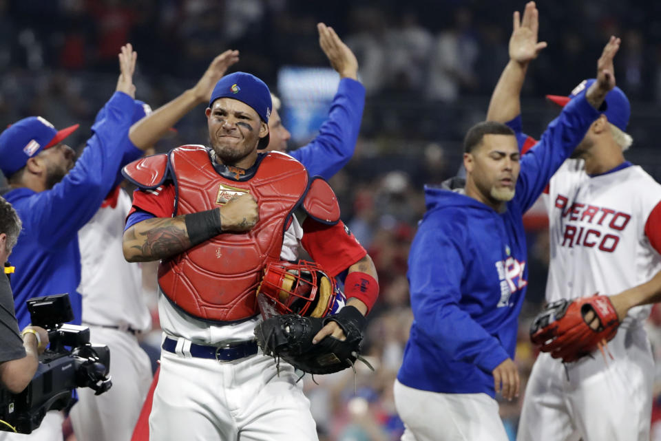 Puerto Rico catcher Yadier Molina, center left, reacts with teammates after defeating the Dominican Republic in a second-round World Baseball Classic game Tuesday, March 14, 2017, in San Diego. Puerto Rico won, 3-1. (AP Photo/Gregory Bull)