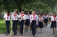 <p>Schoolchildren carry brooms as they walk to various public spaces to sweep and weed the grass in efforts to keep the city clean on July 28, 2017, in Pyongyang, North Korea. (Photo: Wong Maye-E/AP) </p>