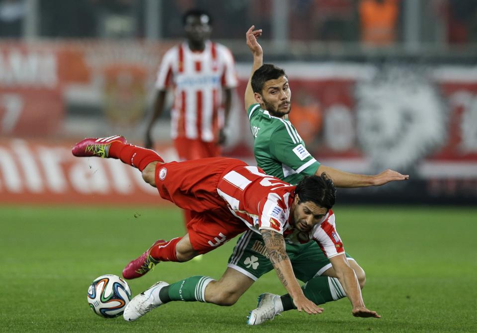 Olympiakos' Alejandro Dominguez, left, is stopped by Panathinaikos' Anastasios Lagos during a Greek League soccer match at Georgios Karaiskakis stadium, in Piraeus port, near Athens, on Sunday, March 2, 2014. (AP Photo/Thanassis Stavrakis)