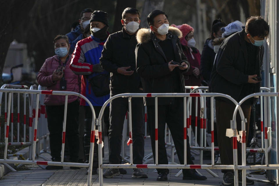 Residents wait in line for their routine COVID-19 test at a coronavirus testing site although authorities start easing some of the anti-virus controls in Beijing, Wednesday, Dec. 7, 2022. China has announced new measures rolling back COVID-19 restrictions, including limiting lockdowns and testing requirements. (AP Photo/Andy Wong)