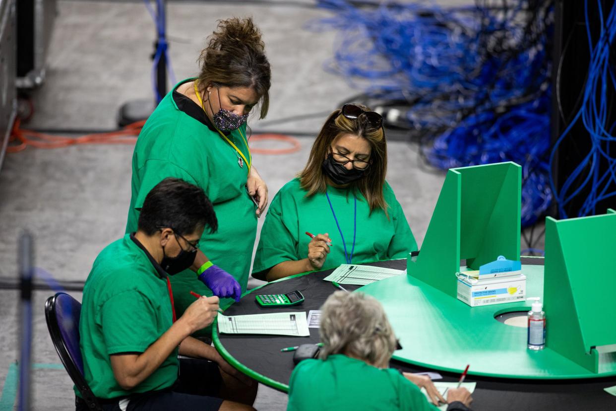 Contractors working for Cyber Ninjas, which was hired by the Arizona state Senate, examine and recount ballots from the 2020 general election in May in Phoenix. (Photo: The Washington Post via Getty Images)