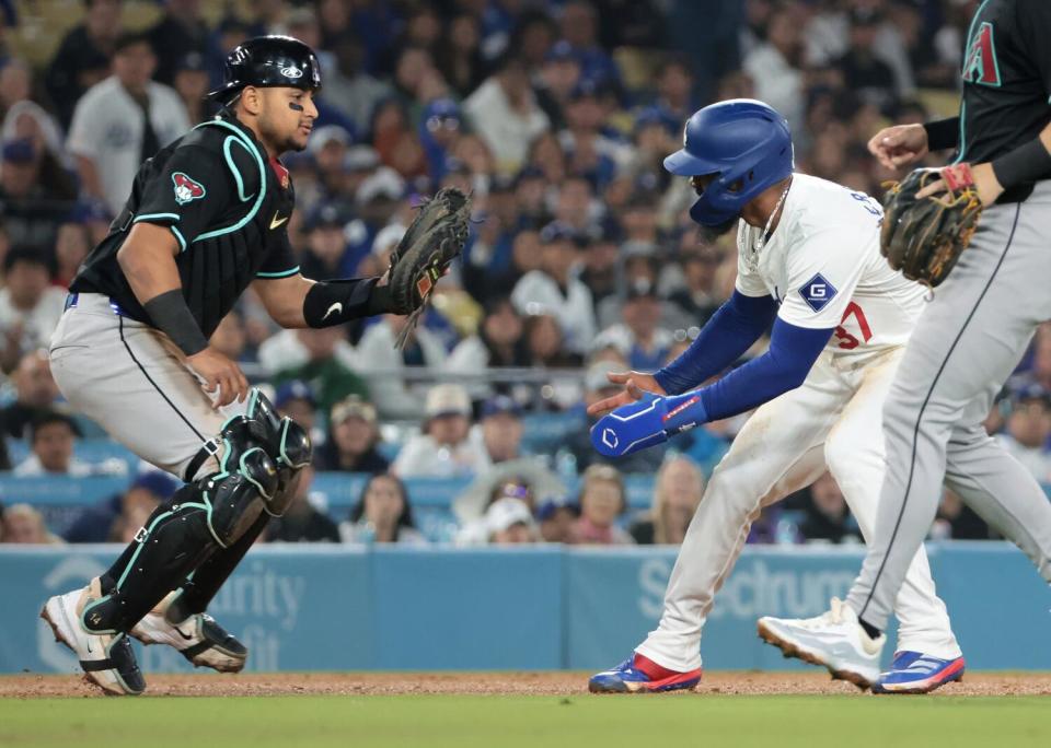 Teoscar Hernández gets caught in a rundown as Arizona catcher Gabriel Montero tags him out in the sixth inning