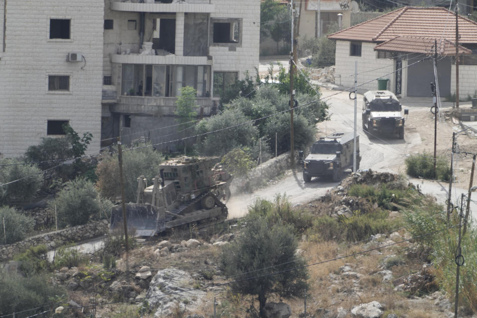 Israeli military vehicles are seen during a raid on Nur Shams refugee camp in the West Bank on Thursday, Oct. 19, 2023. (AP Photo/Majdi Mohammed)