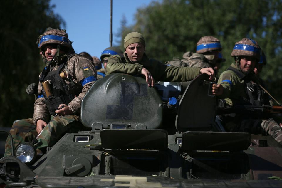 Ukrainian soldiers sit on a armored personnel carrier