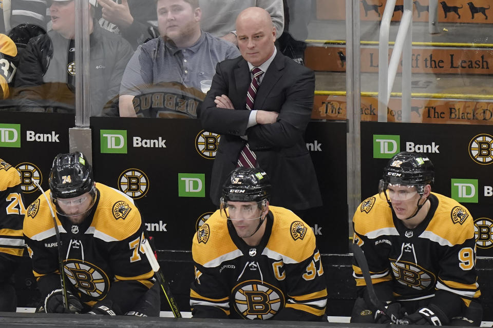 Boston Bruins head coach Jim Montgomery, top, watches from behind the bench during the second period of an NHL hockey game against the Montreal Canadiens, Thursday, March 23, 2023, in Boston. (AP Photo/Steven Senne)