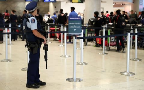 Armed police watch on as members of the Bangladesh cricket team check into Christchurch Airport - Credit: afp