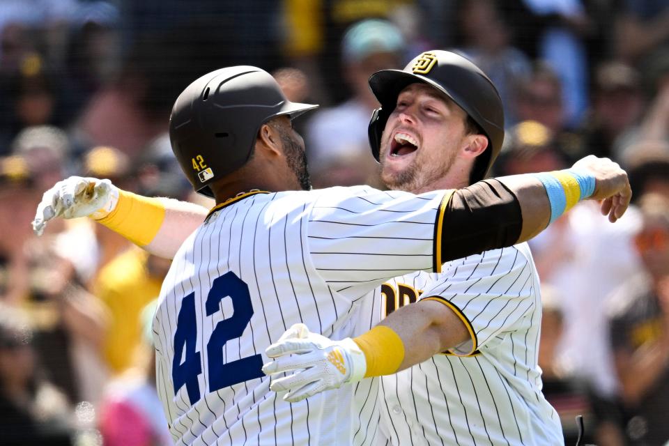 Jake Cronenworth of the Padres is hugged by Nelson Cruz after hitting a two-run home run off Brewers starter Freddy Peralta during the fifth inning Saturday in San Diego.