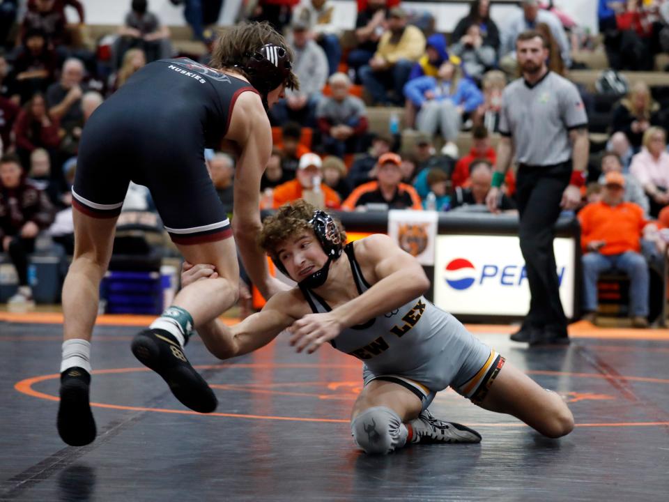 New Lexington freshman Tyson Spicer takes a shot on John Glenn's Kris Wise in the finals at 132 pounds during the Muskingum Valley League Tournament on Saturday at New Lexington High School. The Panthers earned the Small School Division title with the win.