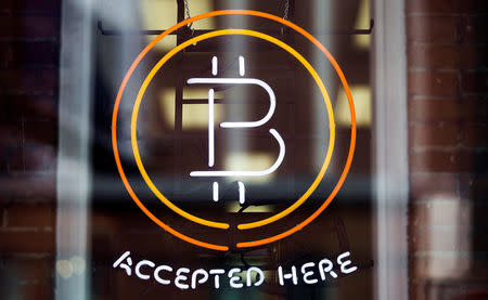 FILE PHOTO: A Bitcoin sign is seen in a window in Toronto, May 8, 2014. REUTERS/Mark Blinch/File Photo