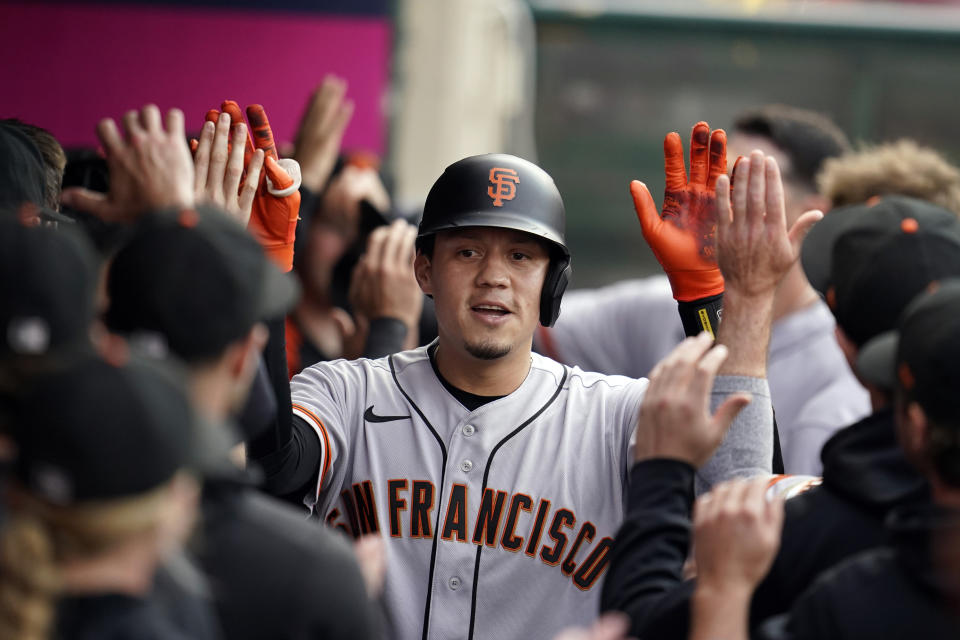 San Francisco Giants' Wilmer Flores celebrates his two-run home run with teammates in the dugout during the first inning of a baseball game against the Los Angeles Angels Tuesday, June 22, 2021, in Anaheim, Calif. (AP Photo/Marcio Jose Sanchez)