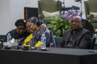 From left, Dorothy Sewe consoles Patrick Lyoya's mother, Dorcas Lyoya, near Lyoya's father, Peter Lyoya, during a news conference at the Renaissance Church of God in Christ Family Life Center in Grand Rapids, Mich. on Thursday, April 14, 2022. Civil rights attorney Ben Crump is representing the family of Patrick Lyoya, who was shot and killed by a GRPD officer on April 4. Sewe is a family friend and refugee from Kenya. (Cory Morse/The Grand Rapids Press via AP)
