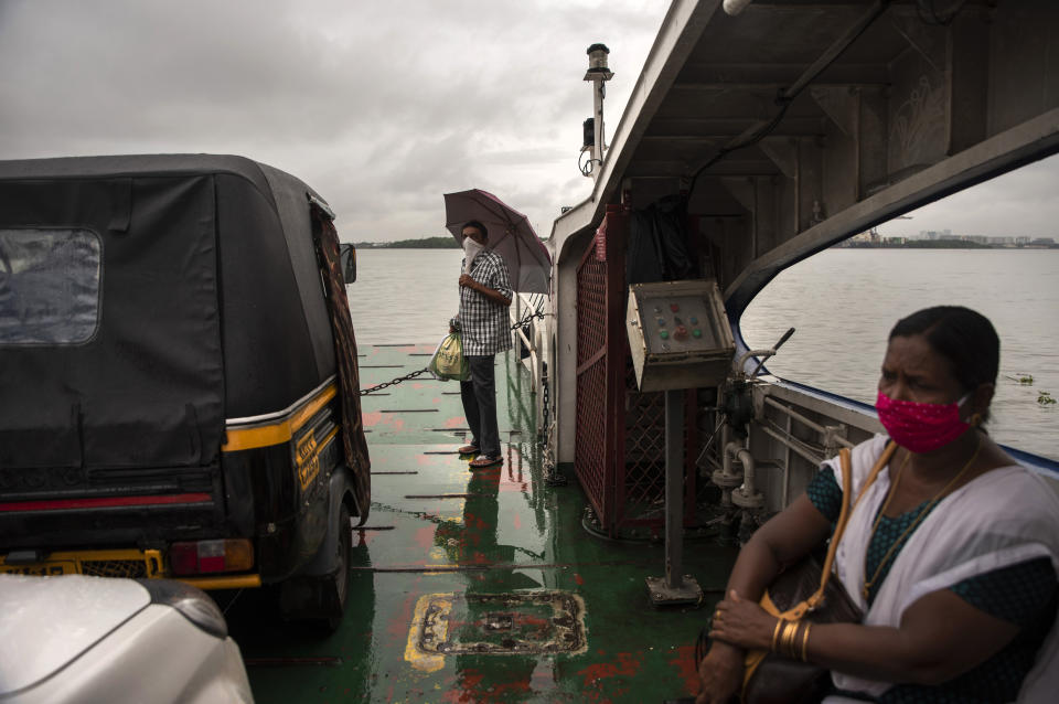 Commuters wearing masks as a precaution against the coronavirus travel in a ferry during rain in Kochi, Kerala state, India, Monday, June 22 2020. India is the fourth hardest-hit country by the COVID-19 pandemic in the world after the U.S., Russia and Brazil. (AP Photo/R S Iyer)