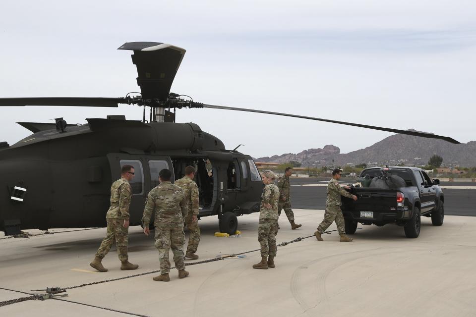 Members of an Arizona National Guard unit pause while loading a helicopter with medical supplies to be taken to the remote Navajo Nation town of Kayenta on March 31. (Photo: (AP Photo/Ross D. Franklin))