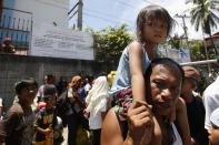 Residents wait for their transport after they were forced to evacuate their village due to fighting between government soldiers and Muslim rebels from the Moro National Liberation Front (MNLF) in Zamboanga city, in southern Philippines September 13, 2013. Local government officials said evacuees have reached to about 20,000 people, as a government stand-off with the MNLF seeking an independent state reaches its fifth day. REUTERS/Erik De Castro (PHILIPPINES - Tags: CIVIL UNREST CONFLICT POLITICS)