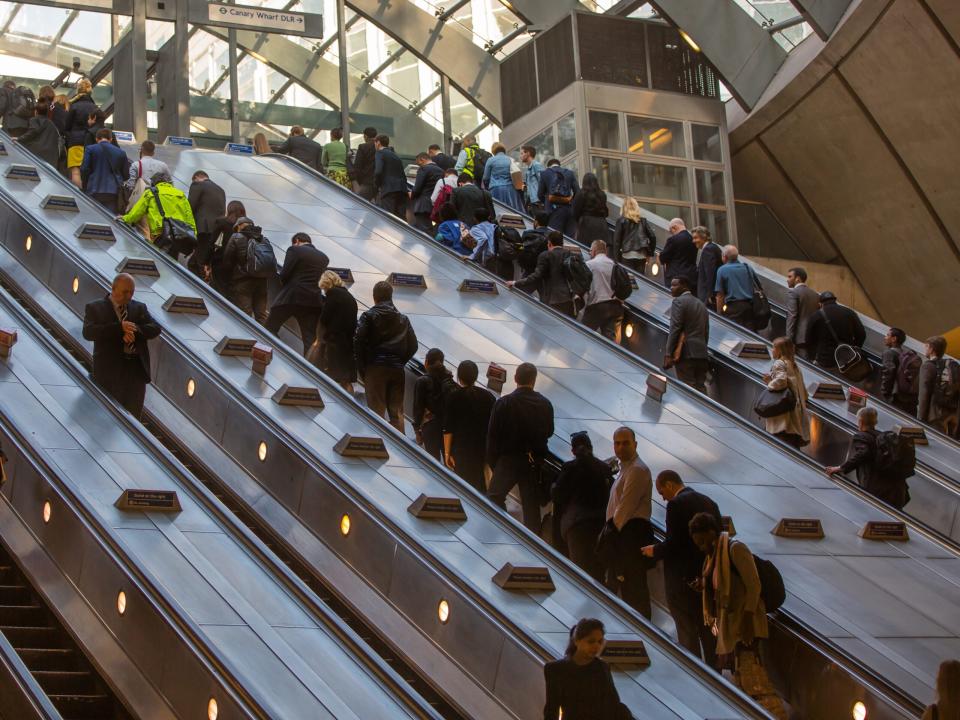 U-Bahn-Eingang Canary Wharf mit Rolltreppen und Menschen in London.