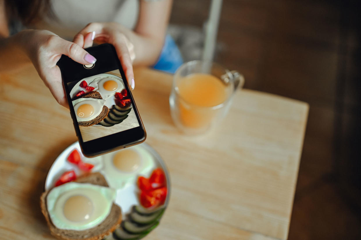 Food blogger using a smartphone to photograph breakfast Getty Images/Netrebina Elena