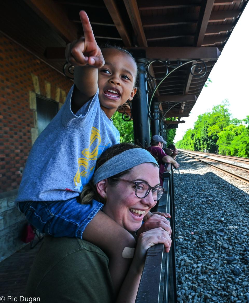 Kalem watches for the steam locomotive 611 as he sits on the shoulders of Tori Himmelberger at the historic High Line Train Station in Greencastle on Thursday.