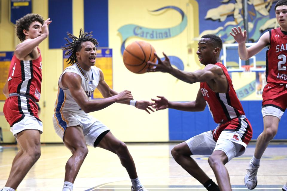 Cardinal Newman's Max Redmon (5) races against Saint Andrew's senior Brooklyn Vick for control of a loose ball during a game on Jan. 30, 2024.