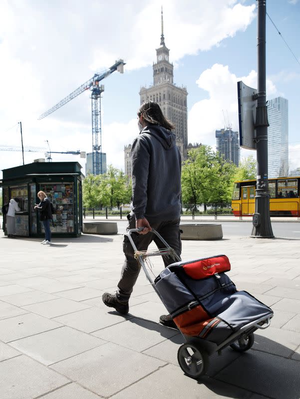 Postman wearing a protectie mask walks with a bag in Warsaw