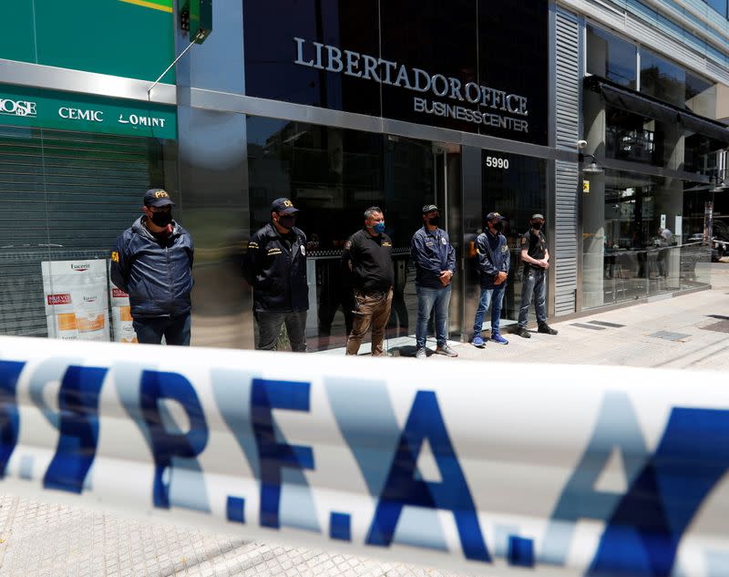 Police officers stand guard outside the building where Dr. Luque has his office in Buenos Aires